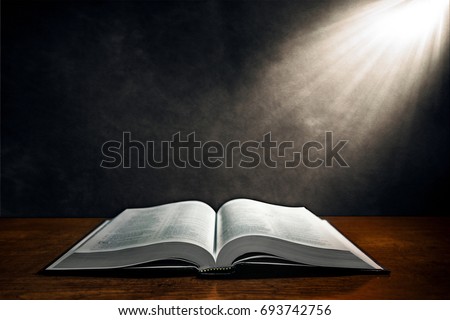 Open Bible on a wood table with light coming from above. ( cristianity concept ).