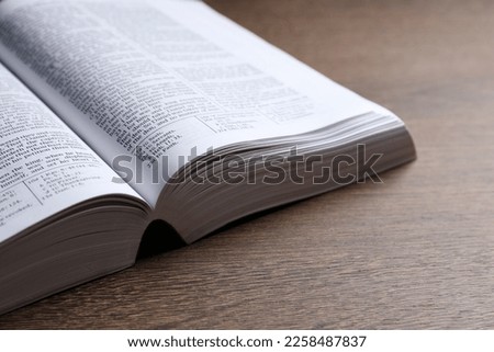 Open Bible on wooden table, closeup. Religious book