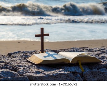 Open bible and wood holy cross with  blue sea as background. - Powered by Shutterstock