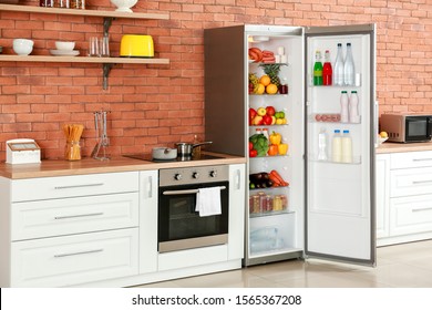 Open Big Fridge With Products In Interior Of Kitchen