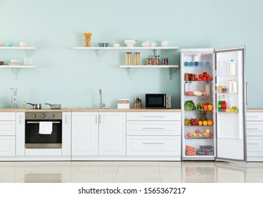 Open Big Fridge With Products In Interior Of Kitchen