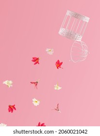 Open bird cage and floating colorful flowers against pastel pink background. Spring buds are bursting out minimal composition. 