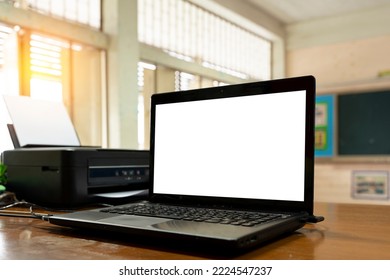 Open black laptop computer on a small chair table in classroom.Modern printer and laptop on table indoor.Creative designer desktop with blank white pc computer display. Front view.Advertising concept. - Powered by Shutterstock