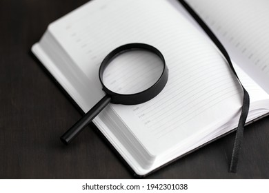 Open Blank Day Planner Lays On Black Table. Black Loupe On Notebook. Time Management. Concepts Of Business Process Planning.