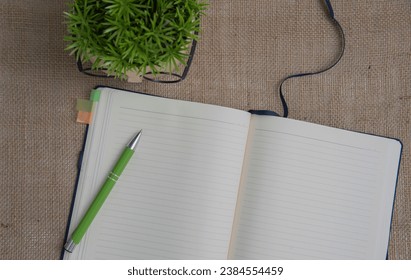 Open blank notepad with empty white pages laying on a table. cozy home setting.