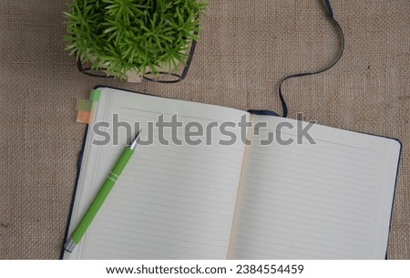 Open blank notepad with empty white pages laying on a table. cozy home setting.