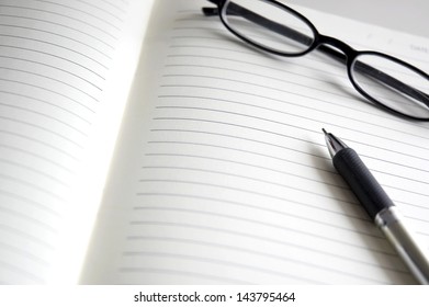 open blank pages of notebook with pen and glasses - Shutterstock ID 143795464