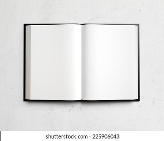 Open blank textbook on white stucco wall
