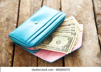 Open Blue Purse With Dollar Banknotes On Wooden Table