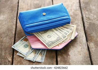 Open Blue Purse With Dollar Banknotes On Wooden Table