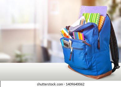 Open Blue School Backpack On A Wooden Desk And Bokeh Background.