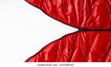 Open blue zipper on red winter down jacket on light background with copy space
