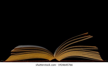 Open Book Against Black Background. Pages Open On An Old Book. Education And History Concept Image With Copy Space.