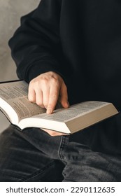 Open book Bible in male hands, close-up.