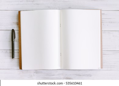 Open book with blank pages on wooden background