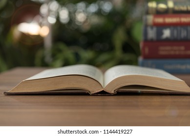 Open Book And Books Stacked On Desk In Library. Legal Education.