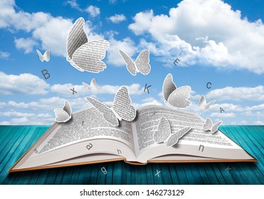 Open book with butterflies letters on blue sky