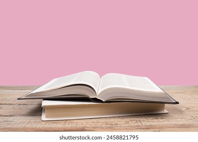 open book. Composition with hardback books, fanned pages on wooden deck table and pink background. Books stacking. Back to school. Copy Space. Education background. Tuition payment. - Powered by Shutterstock