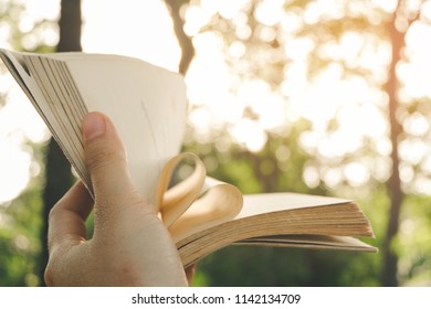 Open book with curled leaves in the shape of a heart - love education and reading concept. - Shutterstock ID 1142134709