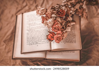 Open book with dried roses lying on its pages, creating vintage and nostalgic atmosphere - Powered by Shutterstock