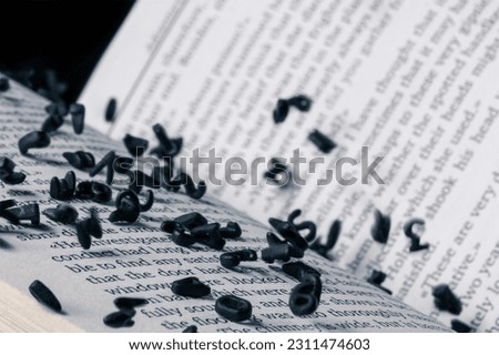 Open book with falling black letters. Letters of the alphabet in levitation in the air over the open book