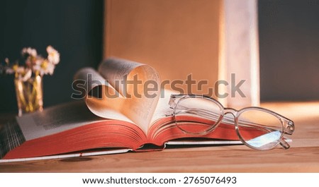 Open book forms heart shape with pages in soft light showcasing reading, love for literature, and the joy of gaining knowledge at a cozy reading spot