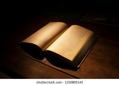 open book illuminated in the dark - Powered by Shutterstock