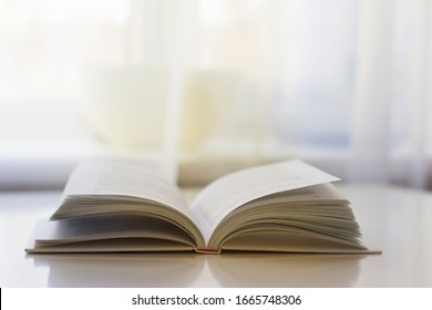 
An open book lies on a white table. Education concept.