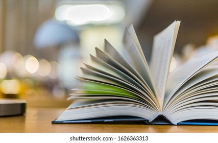 Open book lying on the table in the public library
