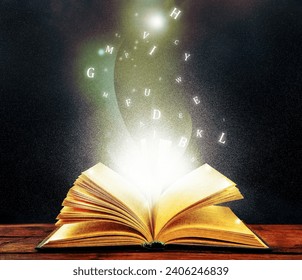 Open book with magic light and glowing letters flying out of it on wooden table against black background - Powered by Shutterstock