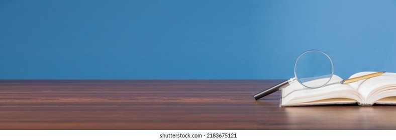 open book with magnifying glass on wooden desk in information library of school or university, concept for education,reading , study, copy space and banner background. - Powered by Shutterstock