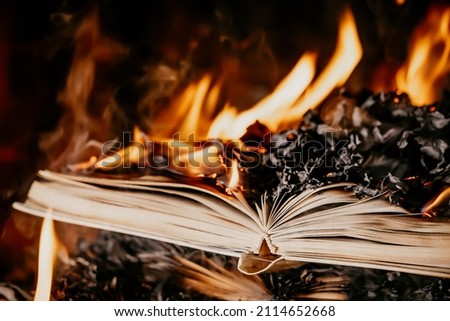 Open book is on fire, pages are engulfed in flames. Concept of censorship, prohibition of freedom information, 451 fahrenheit, old literature in paper format is no longer in demand.