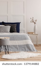 Open Book On Grey Pouf In Trendy Bedroom Interior With Blue And White Design