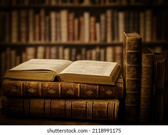 Open Book On A Stack Of Antique Books In A Dark Library.