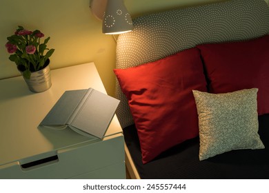 Open Book On The White Nightstand Near The Bed