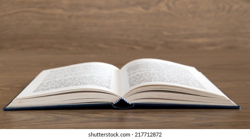 Open book on wood background - Shutterstock ID 217712872