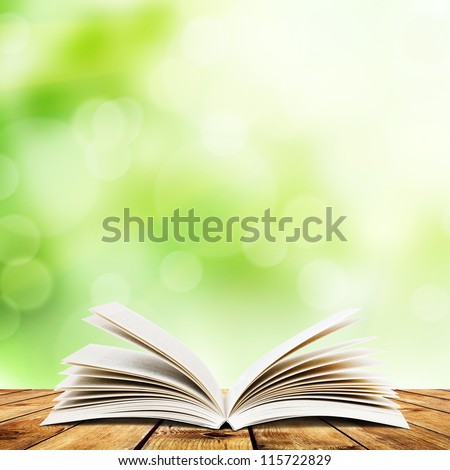 Open book on wood planks over abstract light background