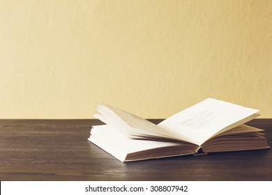 Open Book On Wooden Desk.