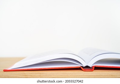 An open book on a wooden shelf and white background