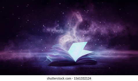 An open book on a wooden table under the night sky against a dark forest. Magical radiance. Night scene. - Shutterstock ID 1561332124