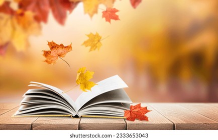 open book in the park on a wooden table with falling autumn leaves and copy space - Powered by Shutterstock