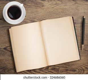 Open Book With Pen And Coffee Cup On Old Wooden Table