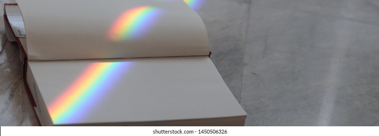 Open Book With Rainbow Streaks In The Library