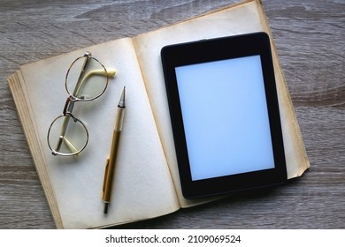 Open Book, Reading Glasses, Golden Mechanical Pencil And E-reader Device On The Table. Top View.