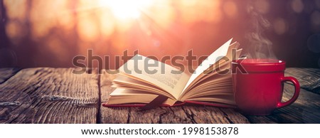 Open Book And Steaming Cup Of Coffee On Wooden Table With Autumn Sunrise Background - Study And Meditation Concept