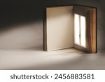 open book with a surreal illuminated window on a page, abstract concept