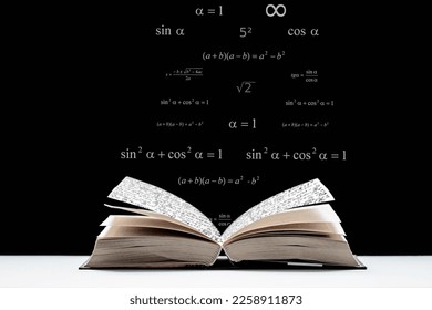An open book, a textbook lies on the table. Metematic signs and formulas on a black background. The study of mathematics, algebra, geometry. - Shutterstock ID 2258911873