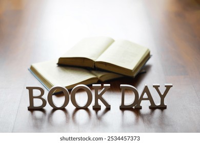 Open Books on Wooden Floor with 'Book Day' Sign Celebrating Reading and Literacy - Powered by Shutterstock