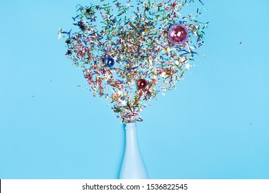 Open Bottle With Confetti Burst Isolated On Blue Background Top View