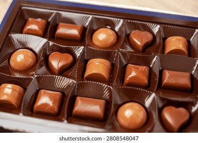 An open box of chocolates. Assorted milk chocolate, praline and dark chocolate.